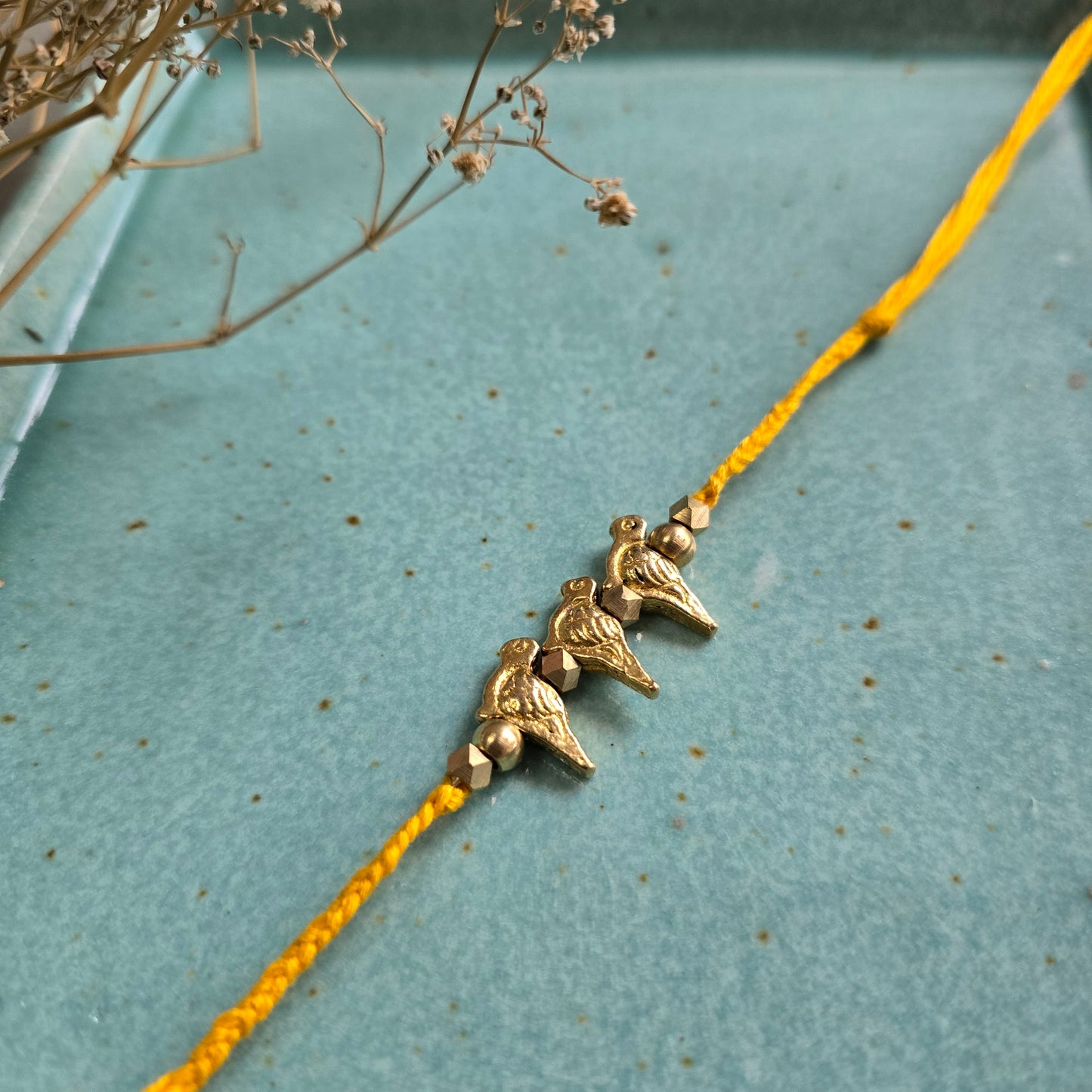 Birdie brass rakhi - mustard yellow