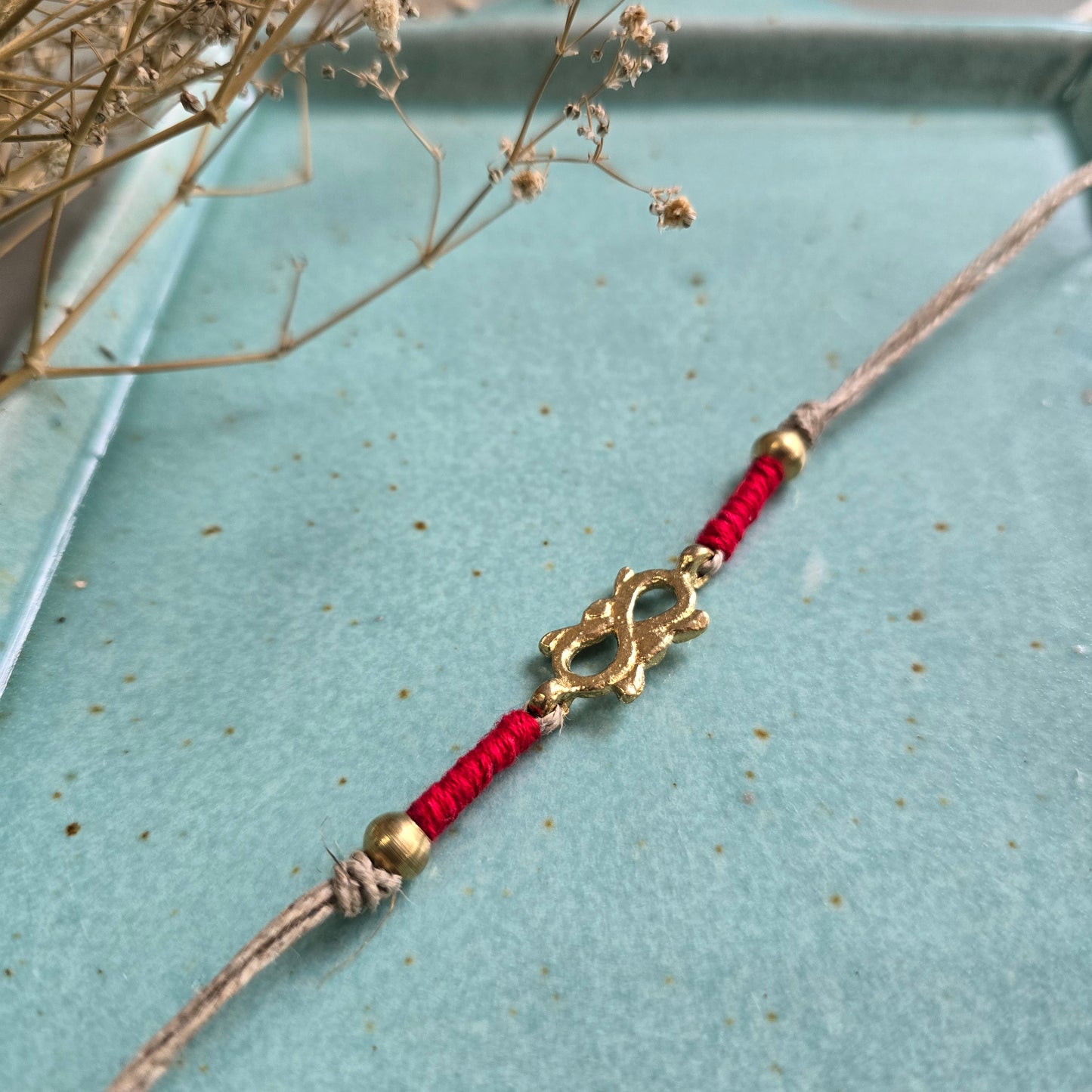 Infinity brass motif rakhi