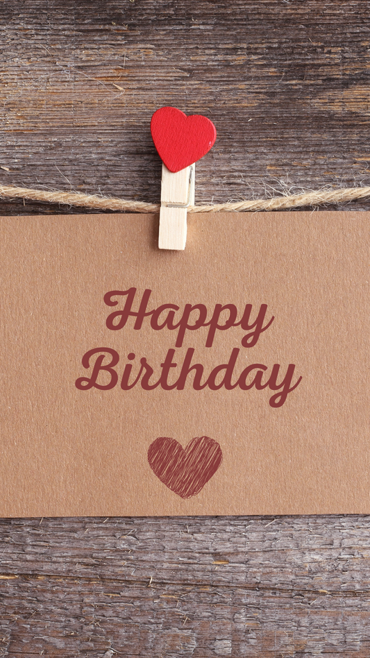 Happy Birthday card with a red heart and clothespin on a wooden background