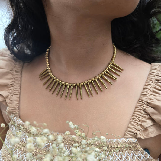 Brass Necklace on a person's neck with a blurred background