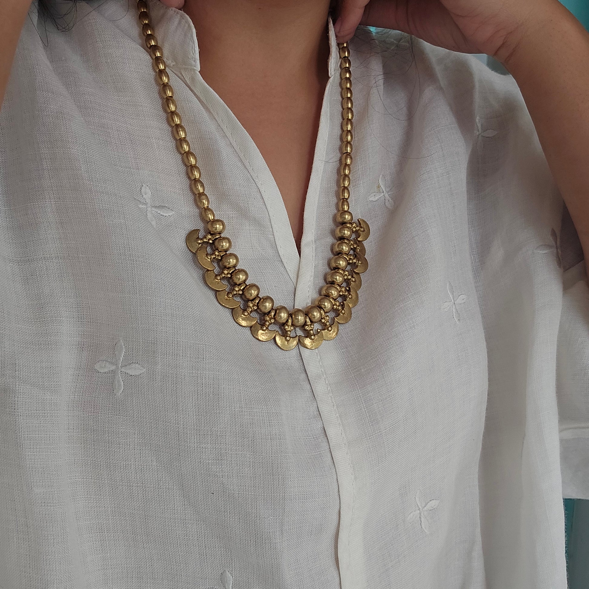 Model wearing Brass beaded and brass charms Mishka necklace